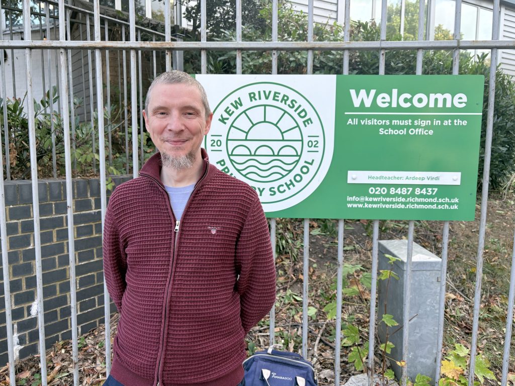 A photo of Richard Newman standing outside Kew Riverside School