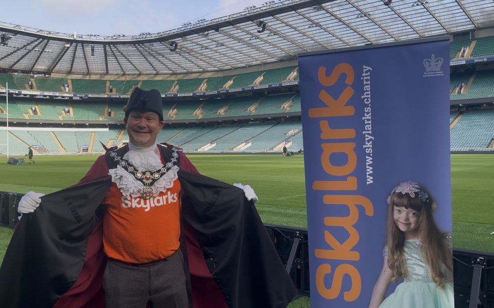 The deputy mayor of Richmond, Matthew Wherry, stands in the Twickenham Allianz stadium revealing his Skylark's charity T-shirt underneath his official robes.