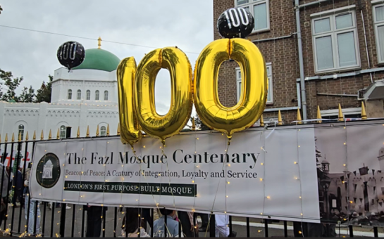 Balloons showing the number '100' flying outside the gates of Fazal Mosque.