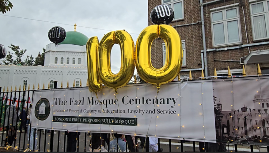 Balloons showing the number '100' flying outside the gates of Fazal Mosque.