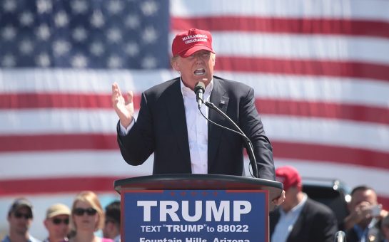 Man wearing cap and standing behind podium
