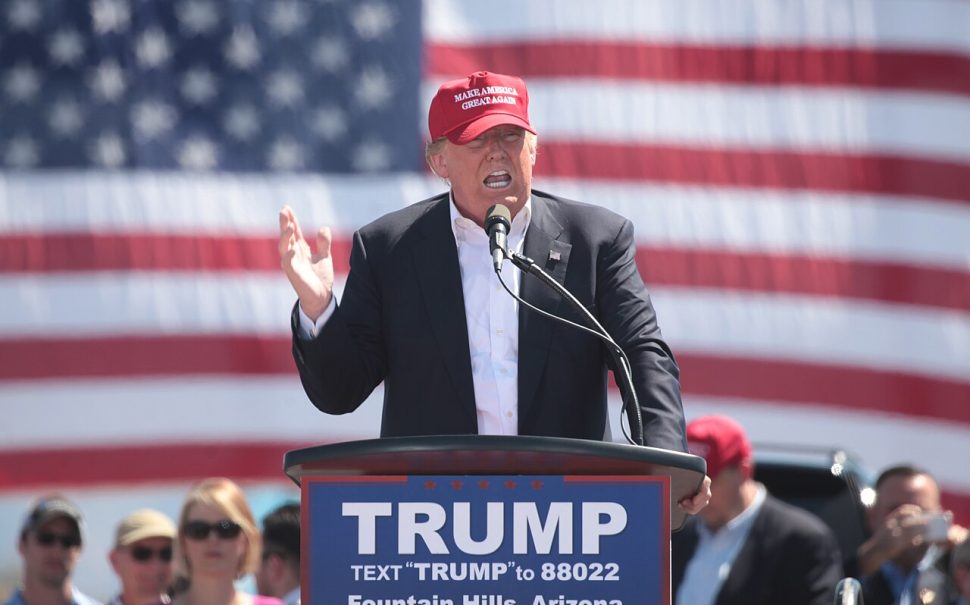 Man wearing cap and standing behind podium