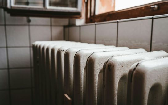 A radiator sits by an open window.