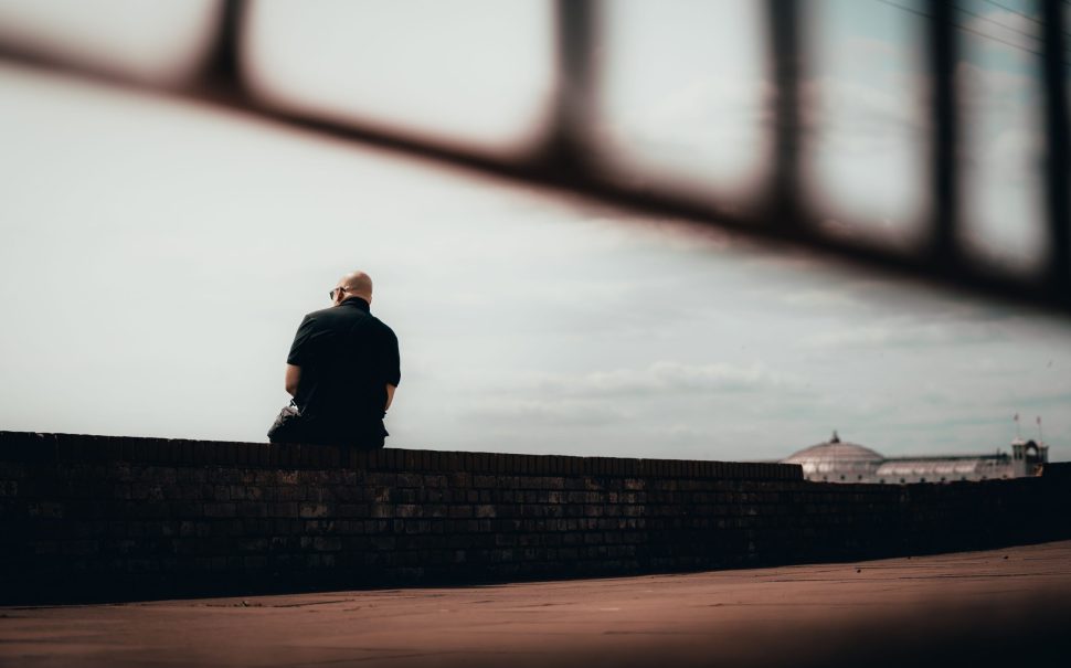 Man sitting alone on wall