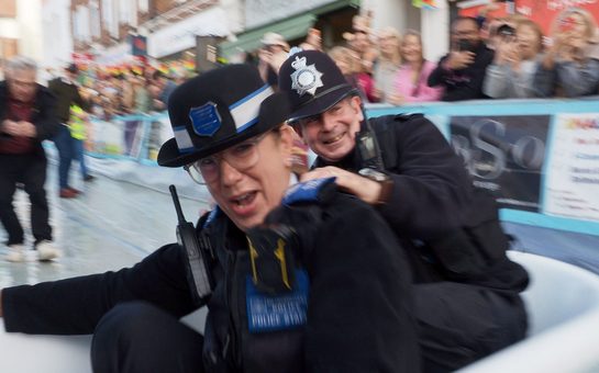 Police officers ride a bath tub down the slope at Surbiton Ski Sunday (Credit: Oliver Monk)